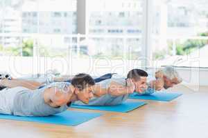Men exercising on mats at gym