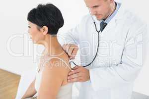 Doctor using stethoscope on back of patient