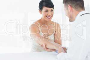 Physiotherapist examining hand of woman