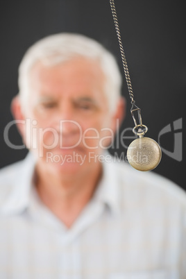 Senior man being hypnotized with pendulum