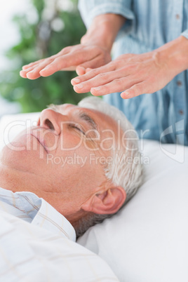 Senior man having Reiki treatment