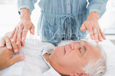 Man having Reiki treatment by therapist