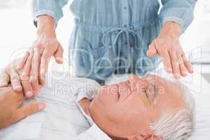 Man having Reiki treatment by therapist