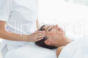 Woman receiving head massage from therapist