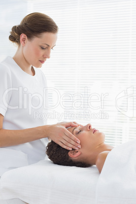 Female therapist giving head massage to woman