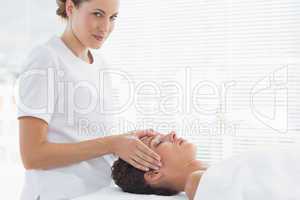 Therapist giving head massage to woman