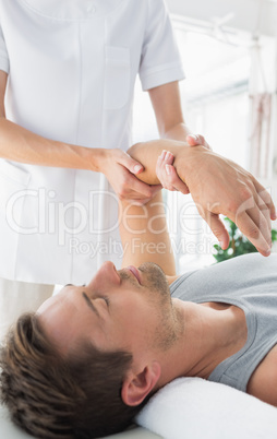 Physiotherapist giving hand massage to man