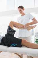 Therapist massaging leg of man