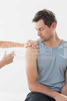 Doctor injecting man on arm in clinic