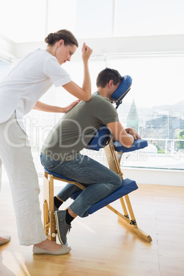 Professional female therapist giving massage to man
