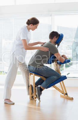 Female therapist massaging man in hospital