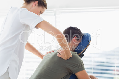 Physiotherapist giving back massage to man