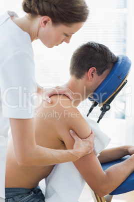 Female therapist massaging man