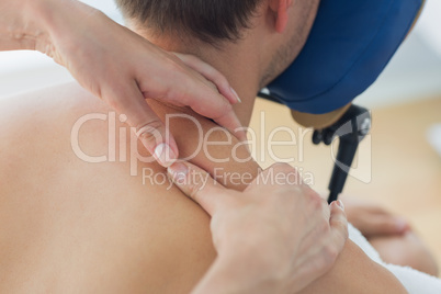 Man receiving shoulder massage by therapist