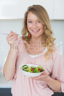 Woman having salad in kitchen