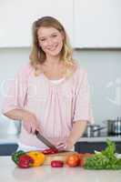 Young woman chopping vegetables at kitchen counter