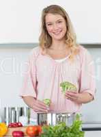 Woman preparing broccoli at kitchen counter