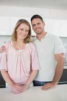Smiling couple standing at kitchen counter