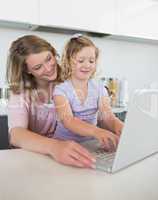 Mother and daughter using laptop together