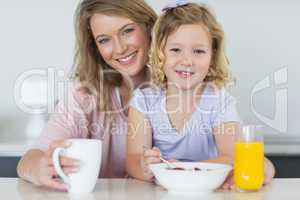 Mother and daughter having breakfast at table