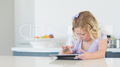 Girl touching digital tablet at table