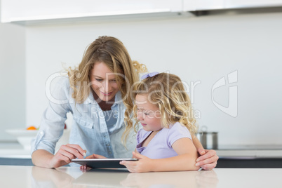 Woman and daughter using tablet computer