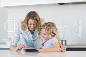 Woman and daughter using tablet computer