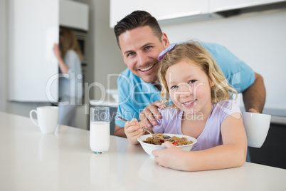 Father and daughter at breakfast table in house