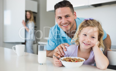 Daughter having breakfast with father at table
