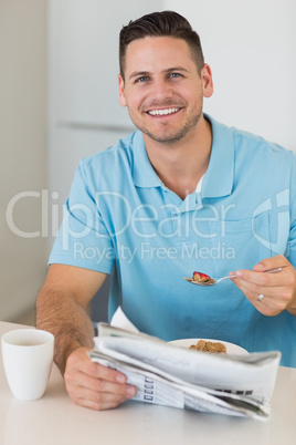 Man with newspaper having breakfast at table