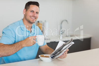 Man having breakfast while holding newspaper