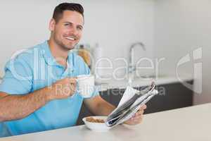 Man having breakfast while holding newspaper