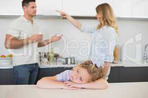 Girl at table with parents arguing in background