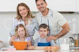Happy family baking cookies at kitchen counter