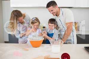 Family preparing cookies at kitchen counter