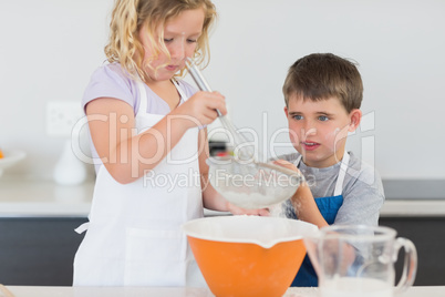 Children preparing cookies in kitchen