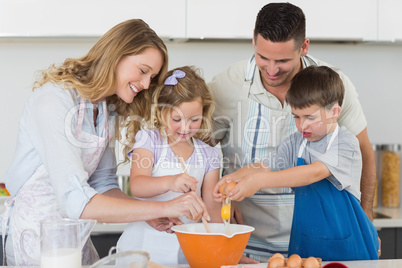 Family mixing egg to bake cookies
