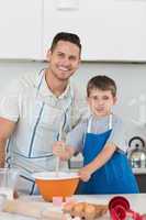 Father and son baking cookies together