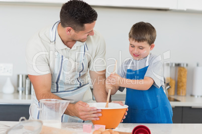 Father and son making cookies at counter