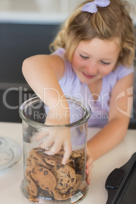 Girl reaching for cookies in jar