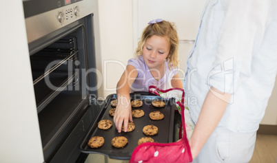 Girl with mother baking cookies