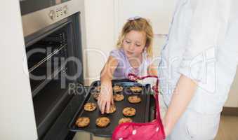 Girl with mother baking cookies