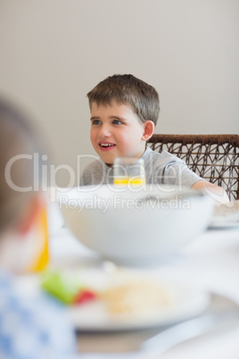Boy looking away at breakfast table