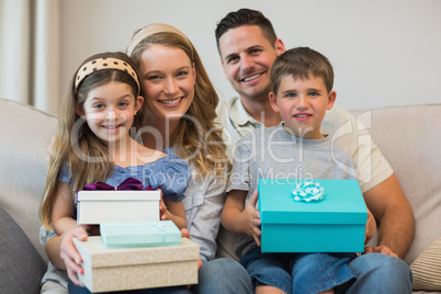 Happy family with gifts on sofa