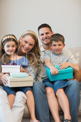 Family with presents sitting on sofa