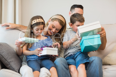 Family opening gifts on sofa