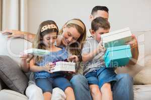 Family opening gifts on sofa