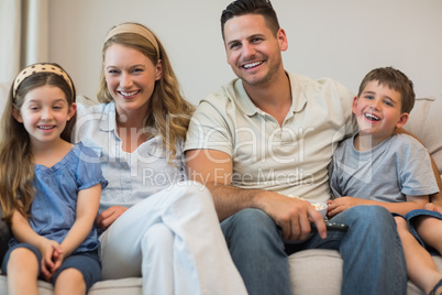 Happy parents and children sitting on sofa