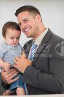 Businessman carrying baby boy at home