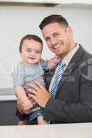 Happy businessman carrying baby boy